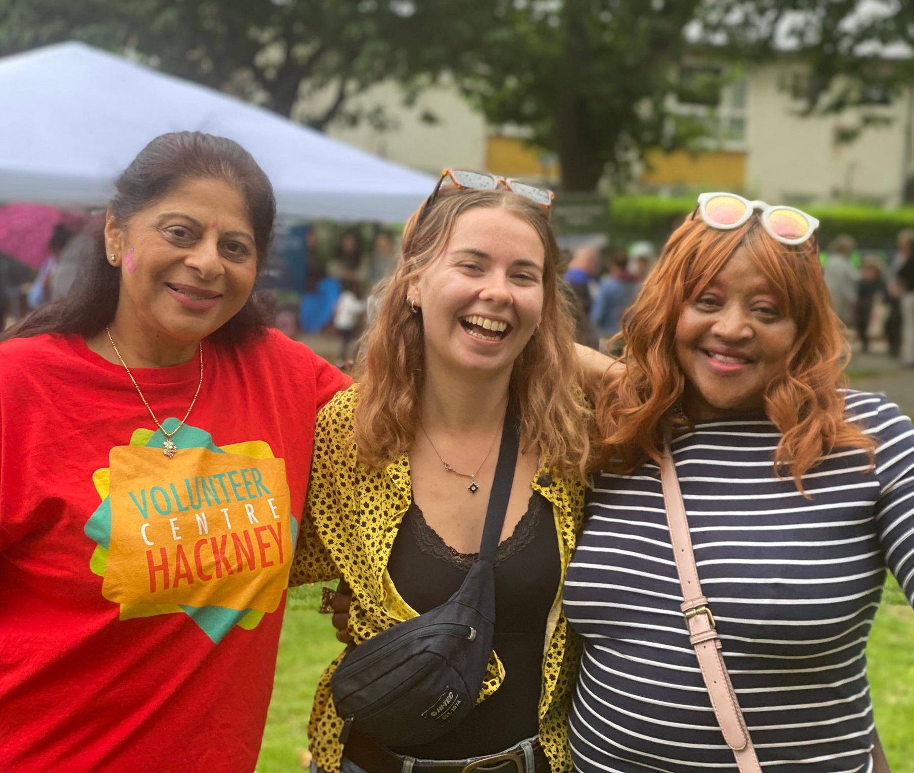 Three people smiling in a park